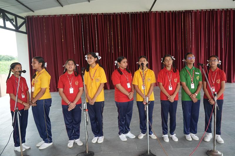 Students performing at microphones on stage